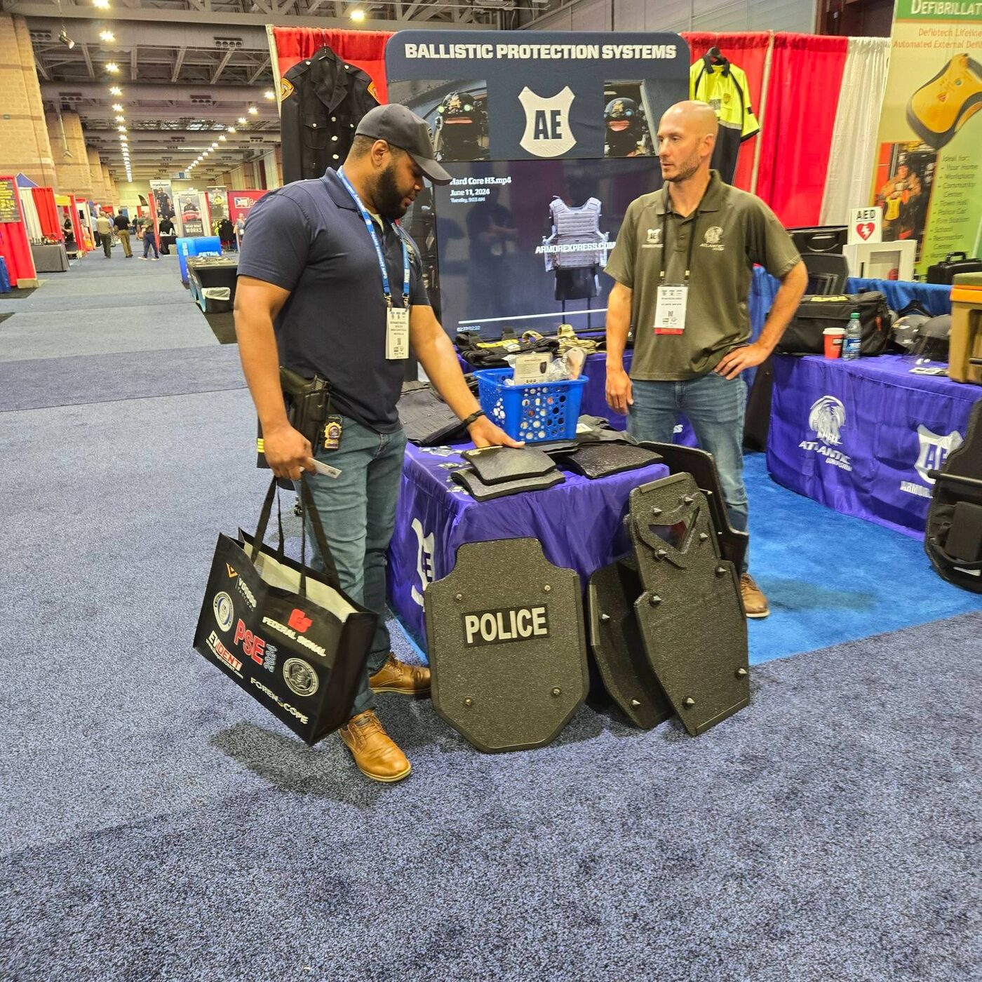 Atlantic Uniform team consulting with officers at a ballistic protection display during a police expo