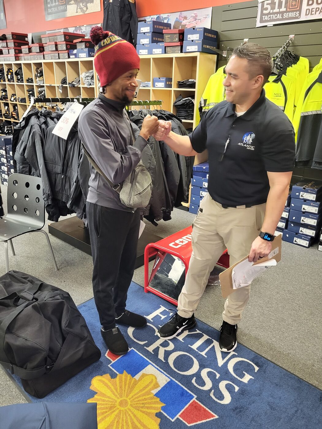 Atlantic Uniform staff congratulating a recruit picking up his academy gear bag in the Belleville showroom